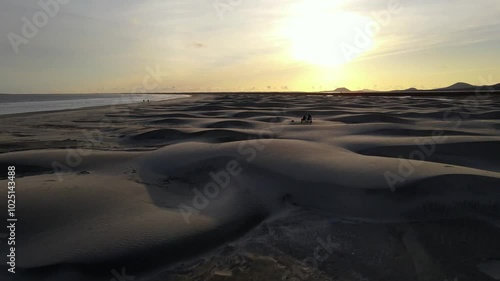 Wallpaper Mural Aerial drone footage of people watching the sunset on an ocean beach and white sand dunes with mountains in the background Torontodigital.ca