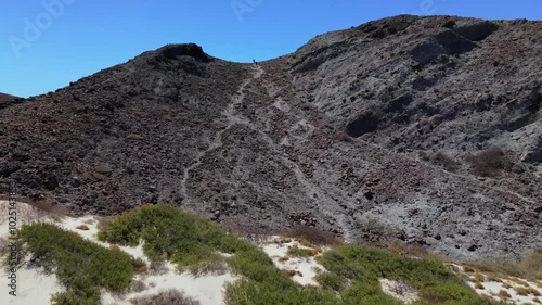 Wallpaper Mural Aerial drone footage of hikers going over a pass overlooking a large bay with turquoise water and desert landscape surrounding on a clear summer day Torontodigital.ca