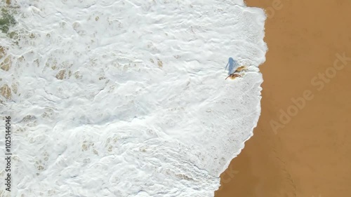Wallpaper Mural Topdown aerial drone footage of a woman walking a white sand beach in front of crashing waves on a clear summer day Torontodigital.ca
