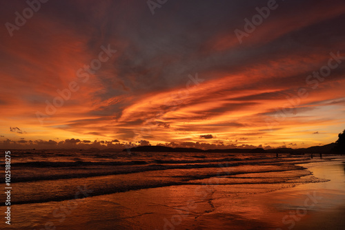 Dramatic sunset with orange sky and clouds on Ao Nang beach in Krabi, Thailand photo