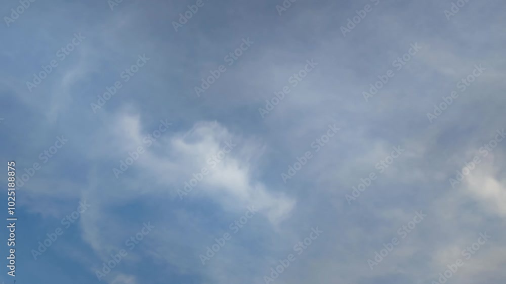 White clouds are moving across the sky. Cumulus and cirrus clouds are slowly floating against the light blue sky, they are at different heights. You can see the sky through the clouds. Clouds of diffe White clouds are moving across the sky. Cumulus and cirrus clouds are slowly floating against the light blue sky, they are at different heights. You can see the sky through the clouds. Clouds of diffe