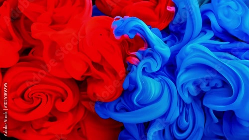 Vibrant swirling clouds of red and blue paint mix together in water, creating an artistic and visually captivating display. The abstract motion and color combinations evoke creativity and expression.