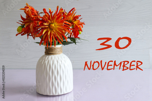 Calendar for November 30: numbers 30, name of the month November, bouquet of yellow dahlias on a light background