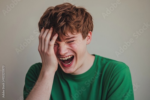 A joyful young man laughs wholeheartedly. His green shirt adds a vibrant touch. This image captures pure happiness and carefree moments. Generative AI photo