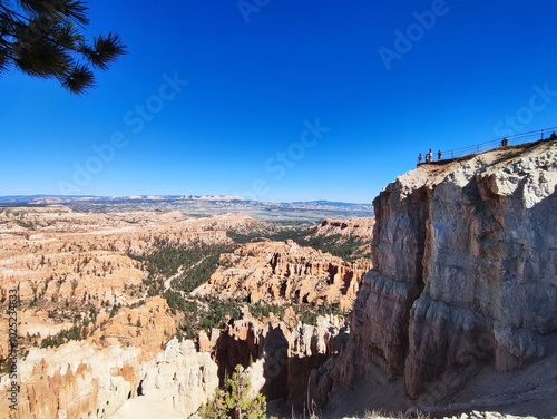 bryce canyon panorama at noon, from nearby the highest cliff, people silhouette on the cliff