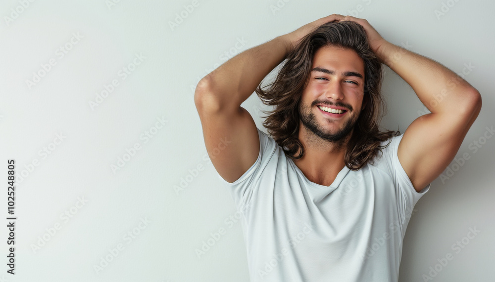 Confident young man with long hair smiling in a casual relaxed pose against a minimalist background Confident young man with long hair smiling in a casual relaxed pose against a minimalist background