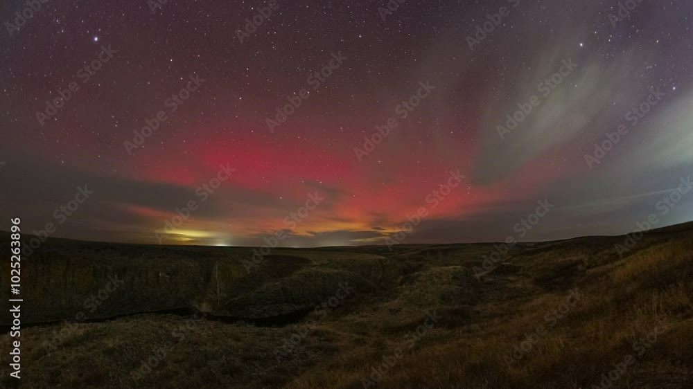 4K Timelapse. Vivid aurora borealis captured in motion with clouds in the dead of night on October 10, 2024. River, tree and rocks in the foreground. Big red glow at the moment of maximum storm 4K Timelapse. Vivid aurora borealis captured in motion with clouds in the dead of night on October 10, 2024. River, tree and rocks in the foreground. Big red glow at the moment of maximum storm