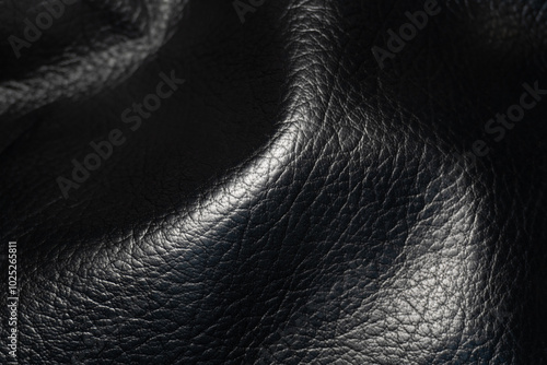 Soft texture of genuine leather. A close-up of soft black leather with minimal patterns, highlighting its natural smoothness and elegance. A premium material for the finest leather goods. photo