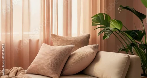 tranquil lindoor space. Warm natural light filtering through sheer curtains. Two softly textured cushions and a lightweight throw placed casually on a low sofa towards one side photo