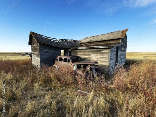 An abandoned old car rusts next to a North Dakota farmhouse