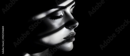 A striking monochrome portrait showcasing a woman's profile, enhanced by dramatic light and shadow patterns.