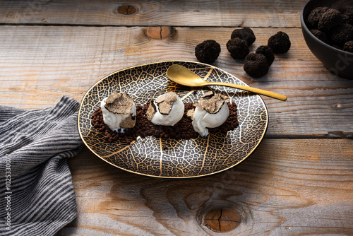 Fototapeta Naklejka Na Ścianę i Meble -  plate with ice cream scoops and sliced ​​truffle on top, on wooden table