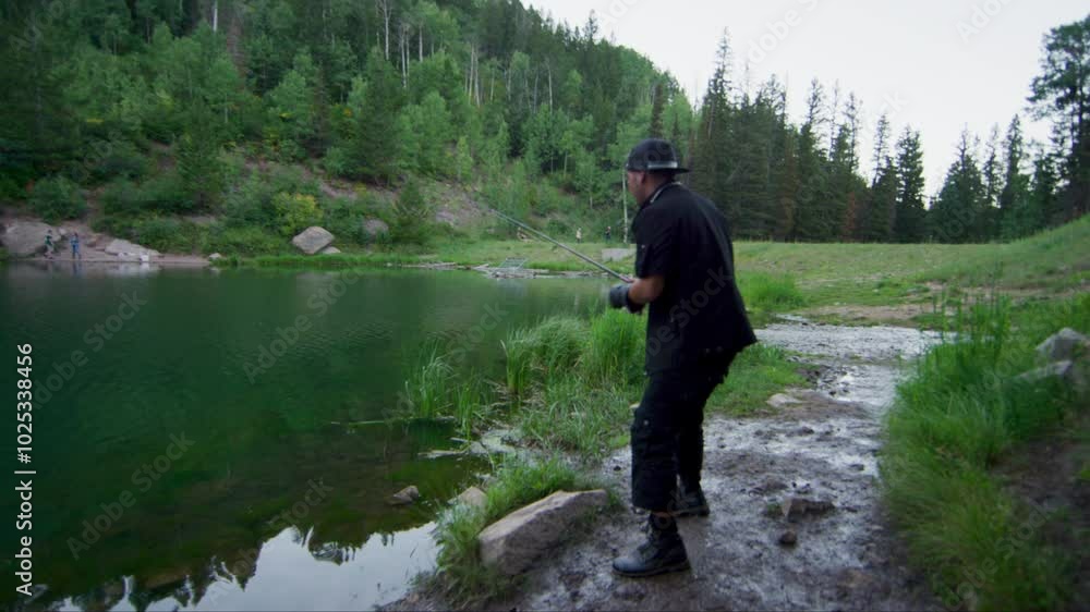 Epic fishing cast on shore of beautiful lake - wide shot Epic fishing cast on shore of beautiful lake - wide shot