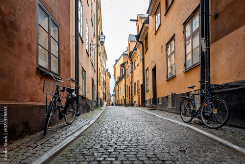 Sweden quaint cobblestone street in picturesque Gamla Stan, Stockholm's oldest neighborhood. Parked bicycles lean against the colorful plaster buildings.