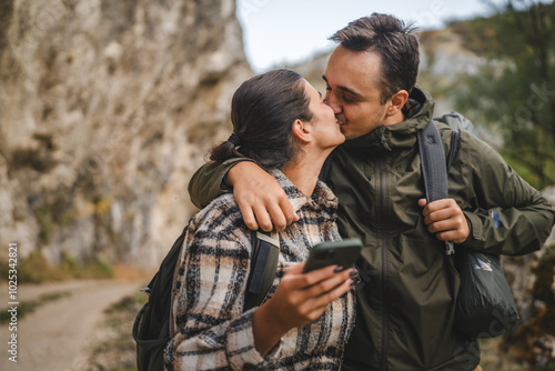 Couple shares a romantic kiss during an outdoor adventure hike