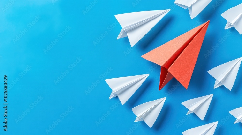 Red Paper Airplane Leading a Flock of White Paper Airplanes on Blue Background Red Paper Airplane Leading a Flock of White Paper Airplanes on Blue Background
