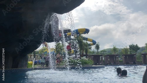 Water playground and water slide in swimming pool water park at summer holiday time in the morning with a bright blue sky as a background. Jakarta, October 13, 2024