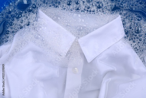 White shirt in suds, closeup. Hand washing laundry