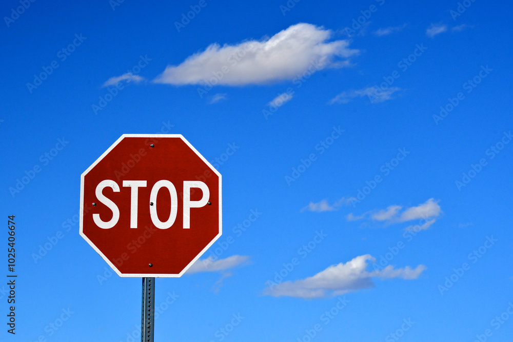 Stop sign, puffy clouds and bright blue sky Stop sign, puffy clouds and bright blue sky