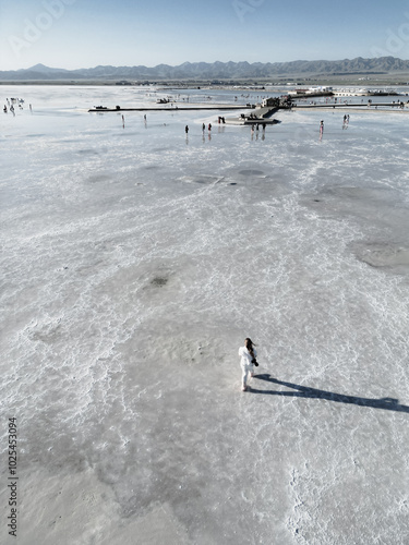 Top drone view on the girl walking towards the viewing platform in Chaka salt lake, Qinghai photo