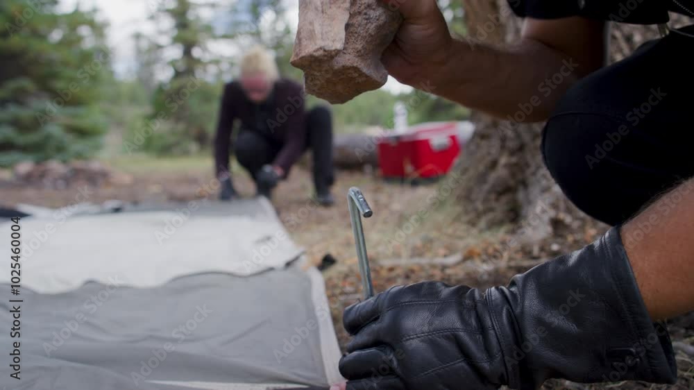 Man pounding tent stake into the ground - shaky cam Man pounding tent stake into the ground - shaky cam