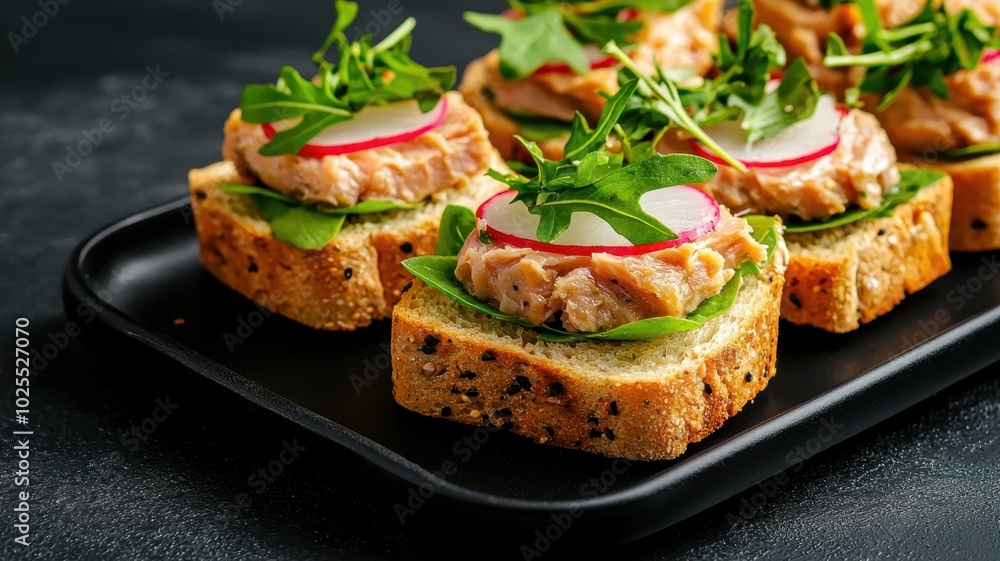 Gourmet Tuna Sandwiches with Fresh Herbs and Radish Slices on Modern Black Plate Gourmet Tuna Sandwiches with Fresh Herbs and Radish Slices on Modern Black Plate