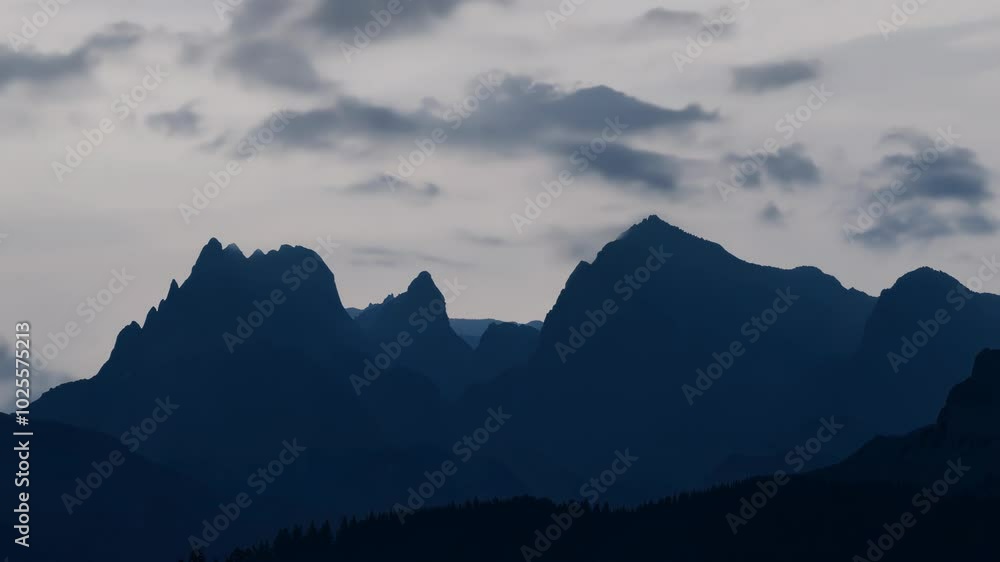 Dark Mountain Silhouettes Against a Cloudy Sky at Dusk Dark Mountain Silhouettes Against a Cloudy Sky at Dusk