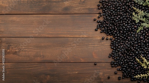 Pile of black beans scattered across a rustic wooden table