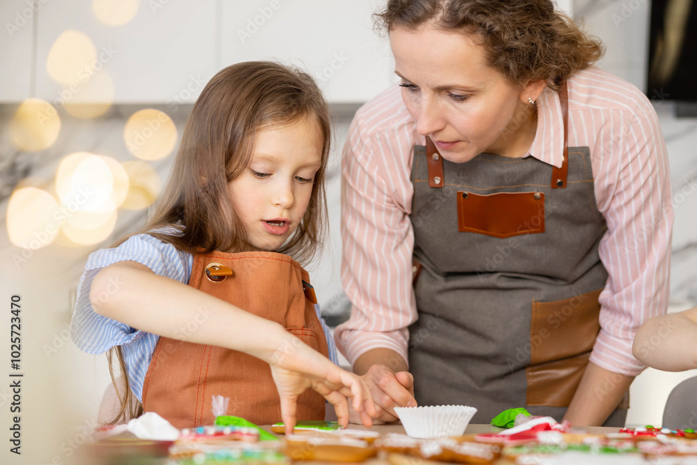 Happy family mother and children in aprons making Christmas cookies together while cooking Happy family mother and children in aprons making Christmas cookies together while cooking