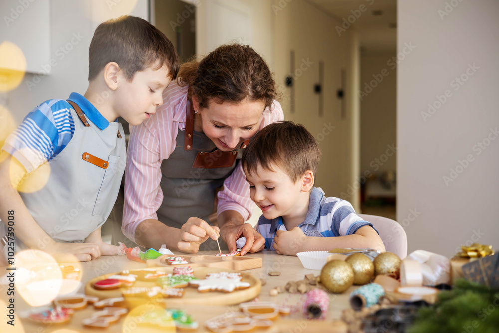 Happy family mother and children in aprons making Christmas cookies together while cooking Happy family mother and children in aprons making Christmas cookies together while cooking