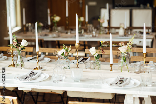 Elegant neutral coloured wedding table scape with flowers and candles