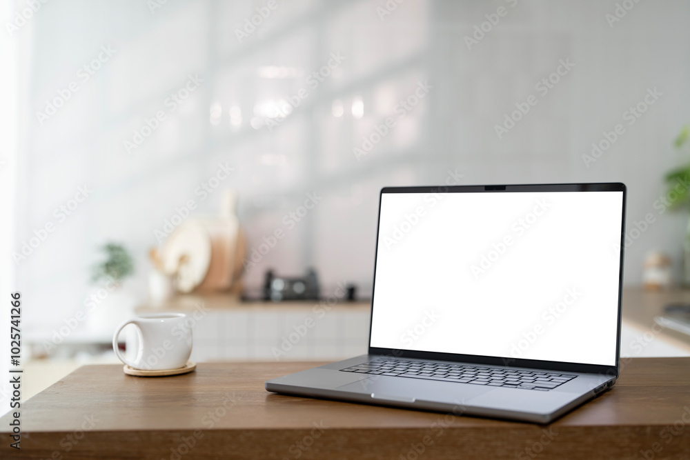 Fototapeta premium Open laptop with blank screen on a wooden desk in a kitchen room home office