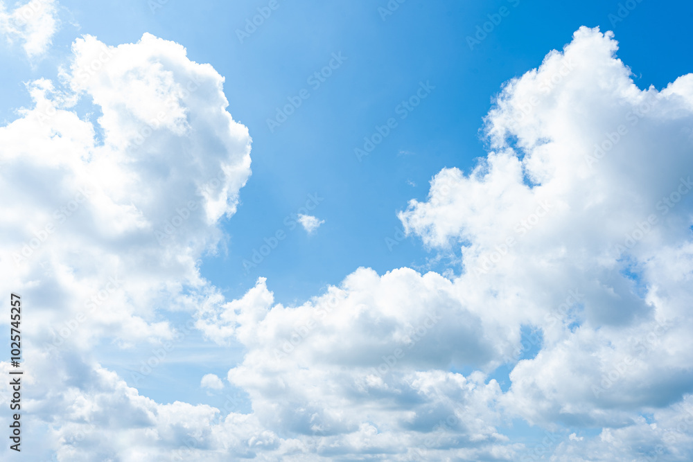 Fluffy white clouds drift across a clear blue sky, painting a beautiful picture of nature's beauty Fluffy white clouds drift across a clear blue sky, painting a beautiful picture of nature's beauty