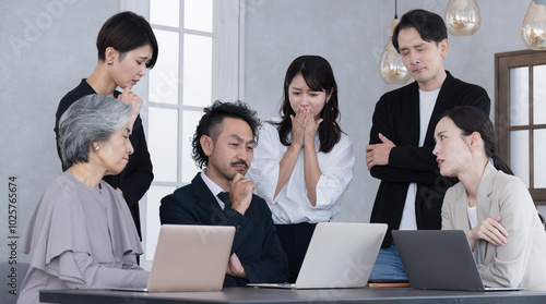 Принти на полотні Multiple businessmen and women working in teams looking at computers Negative images of thinking suffering from declining performance and sales