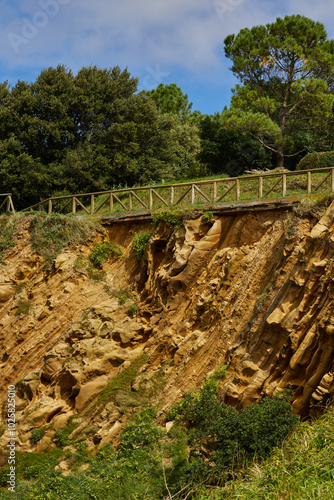 Cliffside trail on Santa Clara Island in San Sebastian, Spain. Landscape with cliff and trees against blue sky.