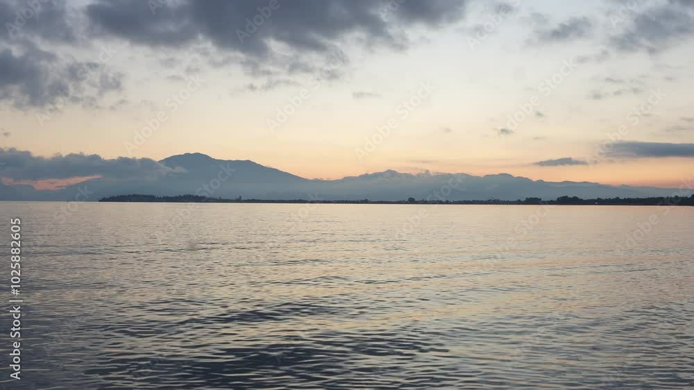 Calm water reflecting changing sky at sunset in Lake Garda, Italy Calm water reflecting changing sky at sunset in Lake Garda, Italy