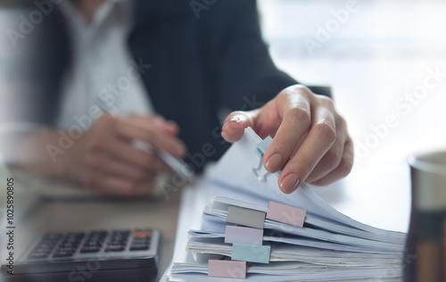 Document management. Businesswoman working with stack of paper files for searching and checking corporate files, document achieves on folders paper on office table, closeup photo