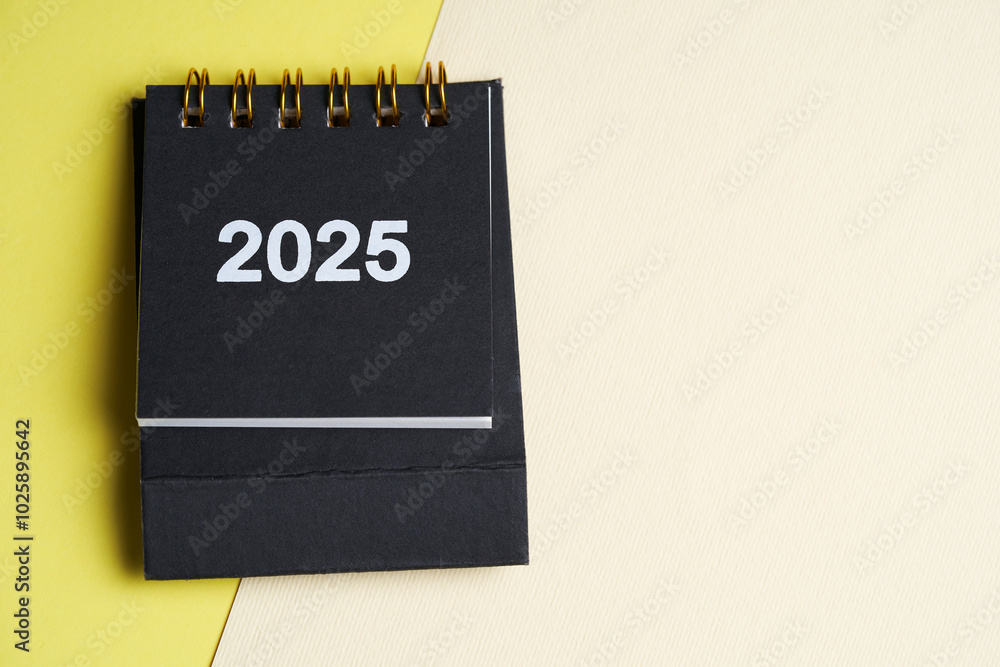 Small desk calendar 2025 on the yellow background Small desk calendar 2025 on the yellow background