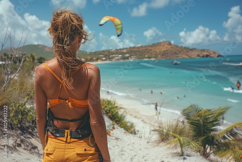 Woman inflating kitesurfing kite with air pump on a sunny beach before exciting watersport adventure