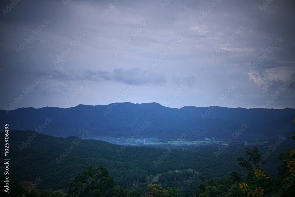 A mountain range with a cloudy sky in the background A mountain range with a cloudy sky in the background