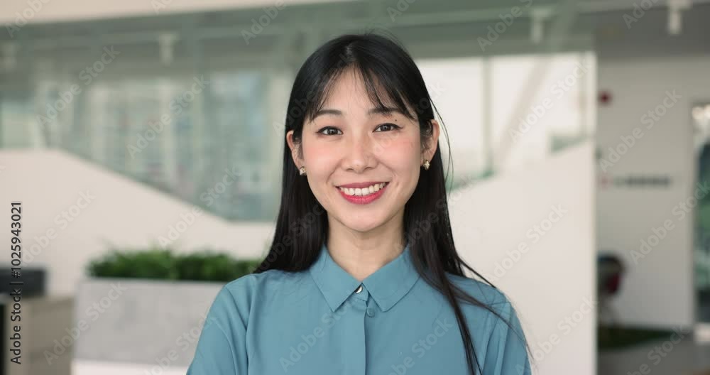 Head shot profile of smiling Asian businesswoman posing in corporate office. Portrait of satisfied young and skilled company executive, hired employee, promoted worker or applicant, front view shot Head shot profile of smiling Asian businesswoman posing in corporate office. Portrait of satisfied young and skilled company executive, hired employee, promoted worker or applicant, front view shot