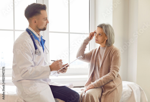 Doctor consulting female senior patient sharing symptoms, express dissatisfaction, annoyance about head, memory. Old woman visiting clinic room for medical care, discussing treatment plan, asking help