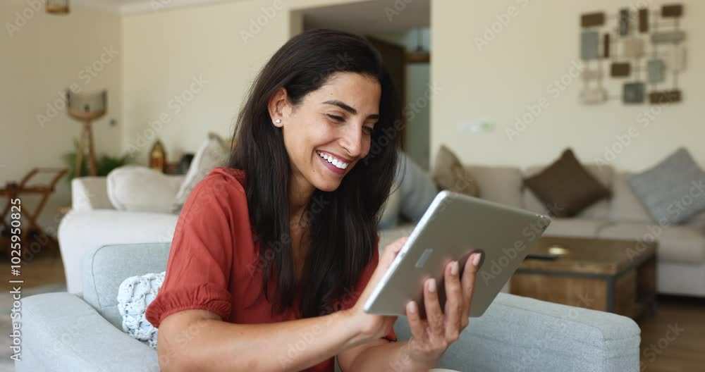 Smiling Latina woman using digital tablet for on-line shopping, remote communication with friend, making order, contact to client, teleworking from home. Modern tech, internet and e-dating app usage Smiling Latina woman using digital tablet for on-line shopping, remote communication with friend, making order, contact to client, teleworking from home. Modern tech, internet and e-dating app usage
