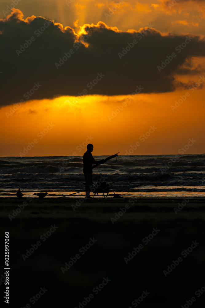 Fototapeta premium Pescador ao Amanhecer na Praia de Peruíbe, São Paulo, Brasil