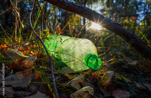 Plastic bottle thrown away in forest. Garbage in nature, reusable products. Rubbish thrown in forest. PET Plastic water bottle thrown out in nature. Waste in nature. Abandoned pet garbage waste.