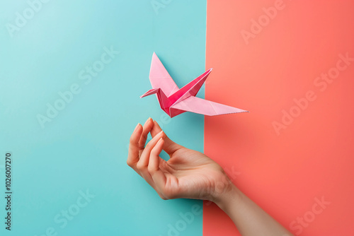 Generative AI origami crane held by hand on colorful background photo