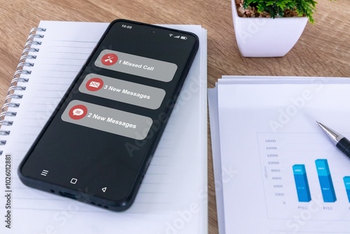 A smartphone on a office desk with missed call and new message notification on the phone screen