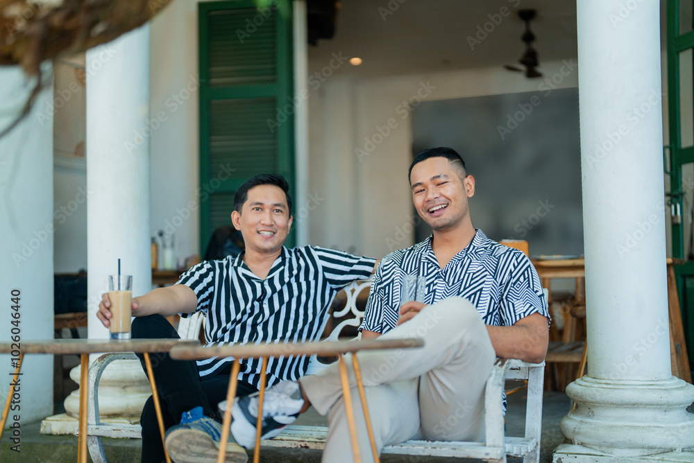 Fototapeta premium A group of friends are cheerfully laughing and sharing drinks in a lovely outdoor space