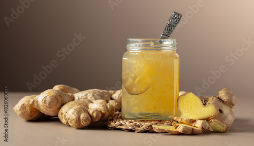 Ginger jam in small square jar and fresh ginger. photo