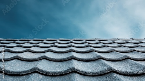 A perspective view of a blue tiled roof under a clear sky, emphasizing architectural design and texture in contrast with the simplicity and calm of the open sky. photo